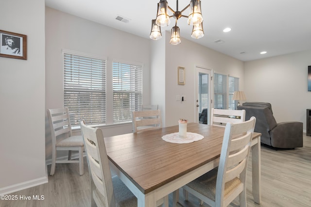 dining room featuring a notable chandelier and light hardwood / wood-style flooring