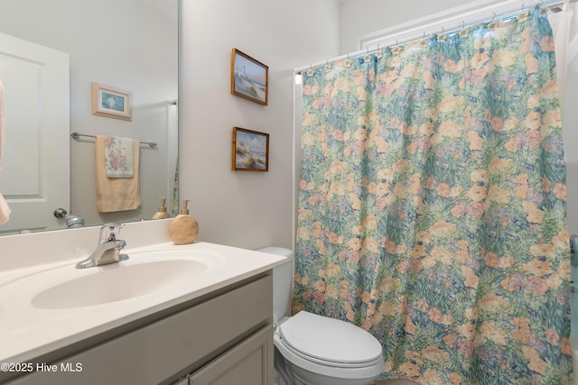 bathroom with a shower with shower curtain, vanity, and toilet