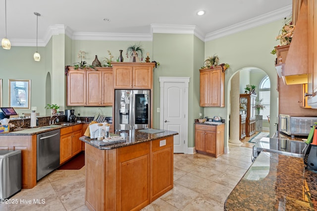 kitchen featuring stainless steel appliances, ornamental molding, and pendant lighting