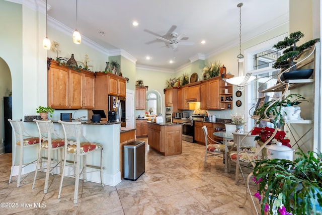 kitchen with kitchen peninsula, a center island, hanging light fixtures, stainless steel appliances, and ceiling fan