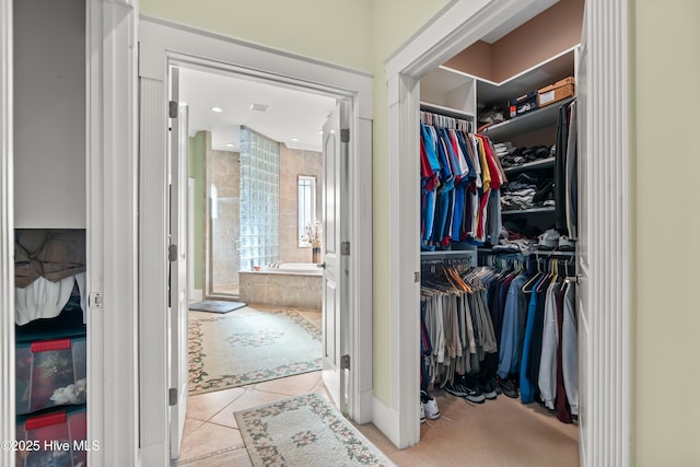 walk in closet with light tile patterned floors