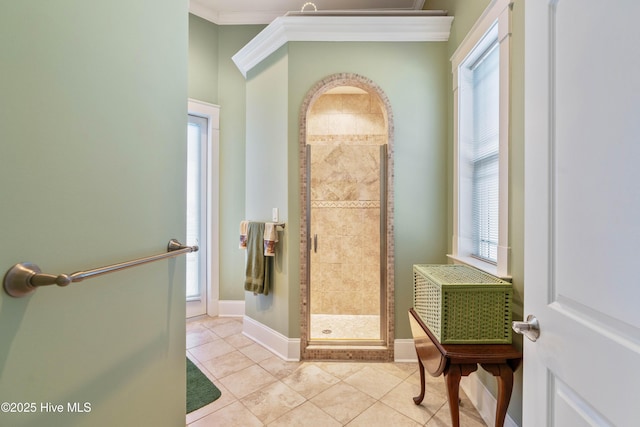 bathroom with a shower with door, tile patterned flooring, plenty of natural light, and crown molding