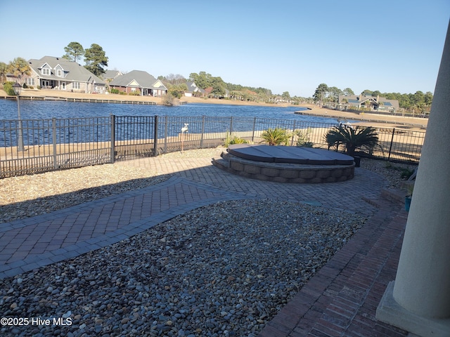 view of yard with a patio area, a jacuzzi, and a water view