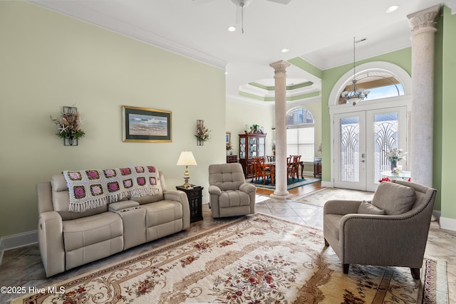 tiled living room featuring ornate columns, french doors, ceiling fan with notable chandelier, and crown molding