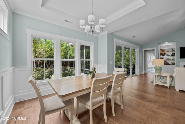 dining area with built in shelves, plenty of natural light, dark wood-type flooring, and a chandelier