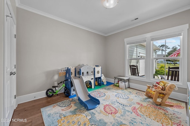 recreation room featuring hardwood / wood-style floors and crown molding