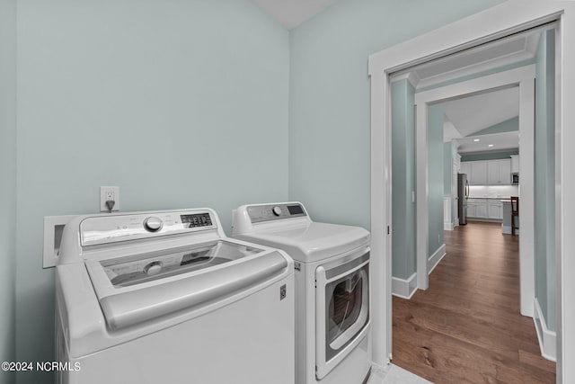 clothes washing area featuring washer and clothes dryer and wood-type flooring