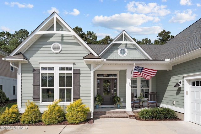 view of exterior entry featuring covered porch and a garage