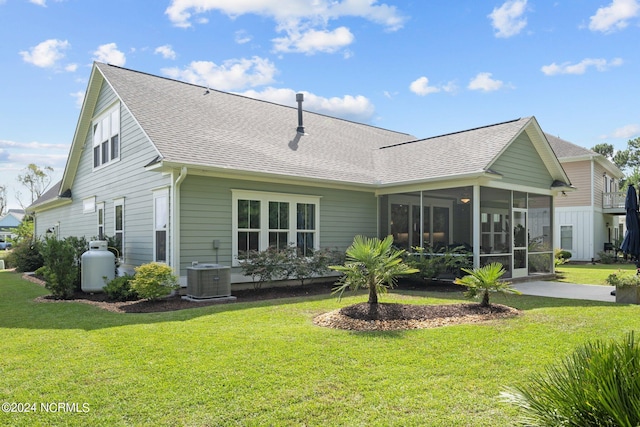 rear view of property with a yard, central AC unit, and a sunroom