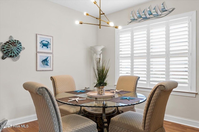 dining area featuring dark wood-type flooring and a chandelier