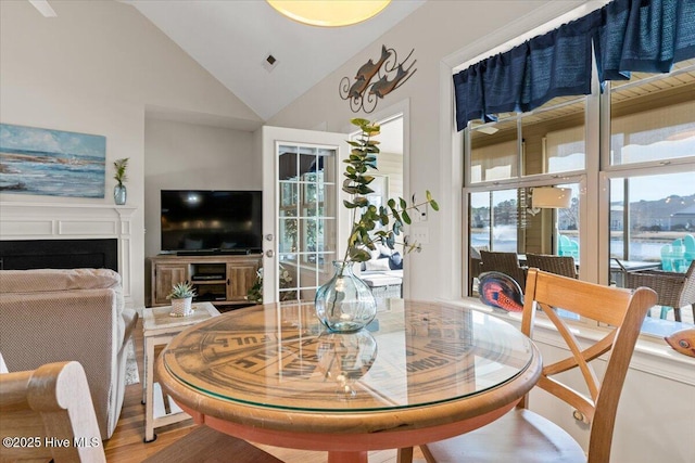 dining space with wood-type flooring and lofted ceiling