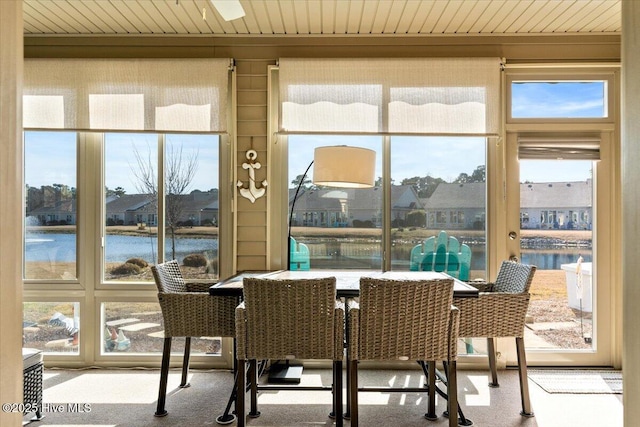 sunroom featuring a water view