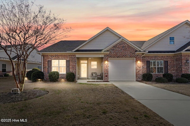 view of front of house featuring a garage and a lawn