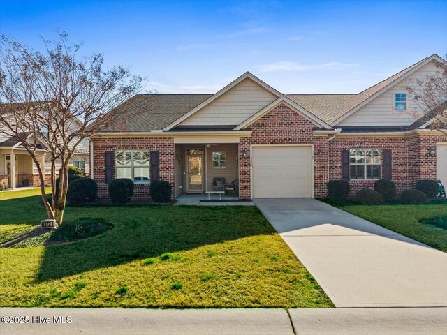 craftsman-style house featuring brick siding, driveway, a front yard, and a garage