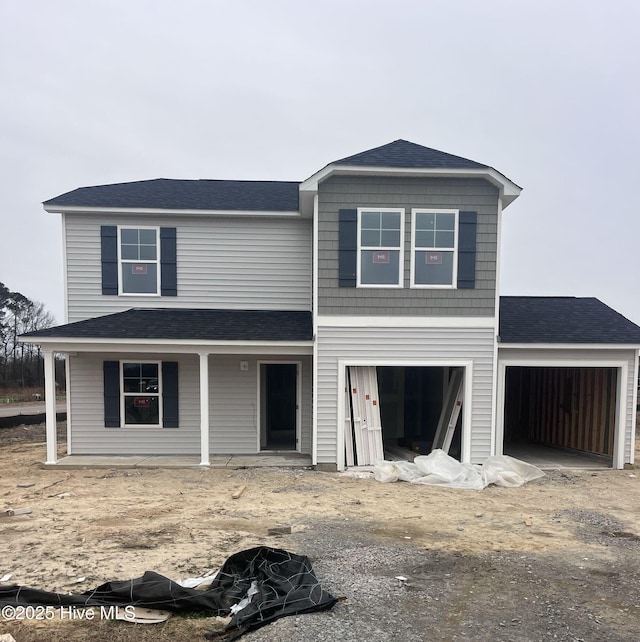 view of property with a porch and a garage