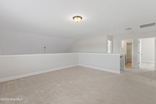 additional living space featuring light colored carpet and lofted ceiling