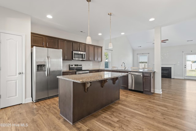 kitchen featuring sink, ceiling fan, a wealth of natural light, appliances with stainless steel finishes, and decorative light fixtures