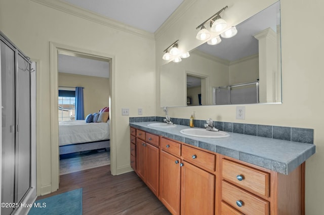 bathroom featuring ornamental molding, a shower with shower door, hardwood / wood-style floors, and vanity