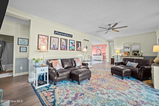 living room featuring crown molding, ceiling fan, and dark wood-type flooring