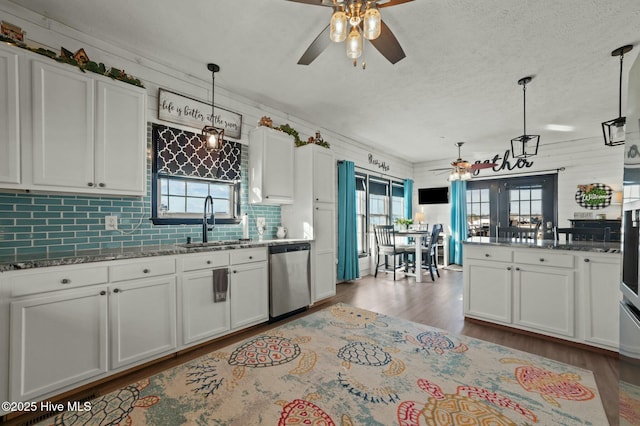 kitchen featuring pendant lighting, sink, white cabinetry, and dishwasher