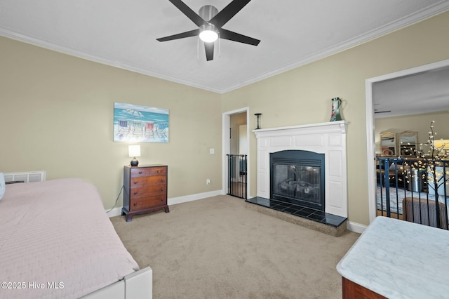 bedroom featuring a tile fireplace, ornamental molding, light carpet, and ceiling fan