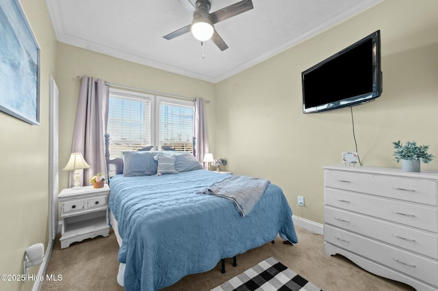 carpeted bedroom with ornamental molding and ceiling fan