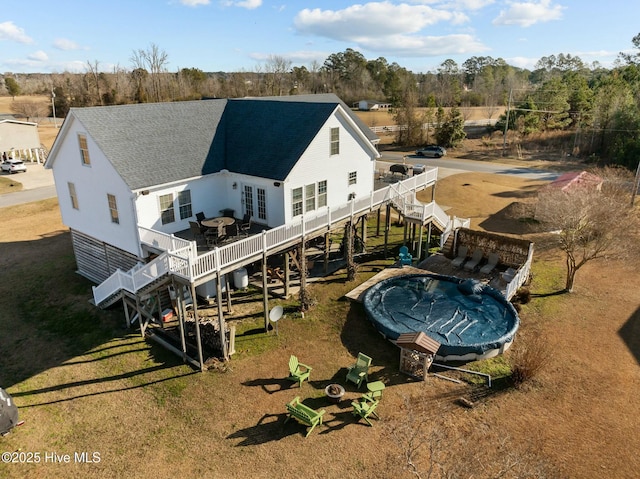 back of house with a deck and a lawn