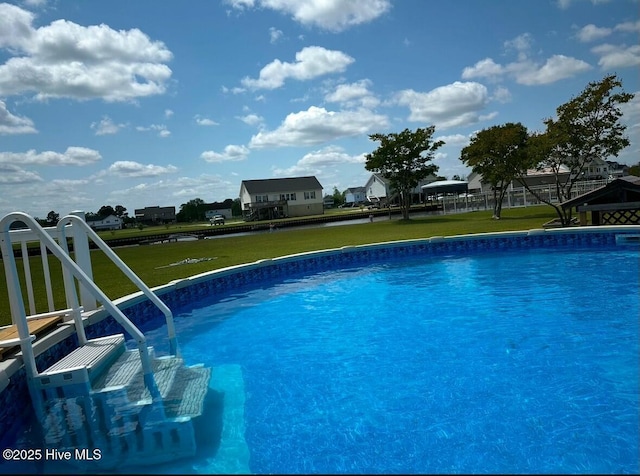 view of swimming pool featuring a yard