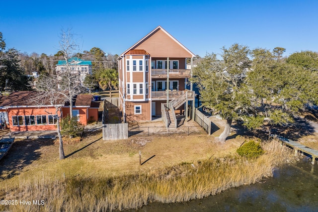 back of house featuring a balcony and a water view