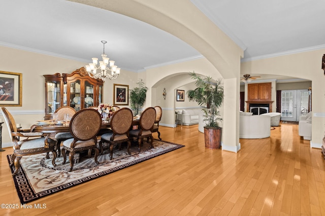 dining area featuring crown molding, ceiling fan with notable chandelier, and light wood-type flooring