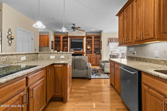 kitchen with ceiling fan, hanging light fixtures, light stone counters, stainless steel dishwasher, and light wood-type flooring