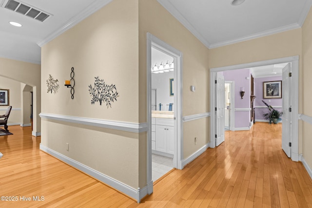 hall featuring crown molding and light hardwood / wood-style floors