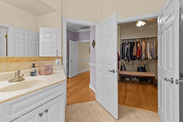 bathroom featuring tile patterned flooring, vanity, and crown molding