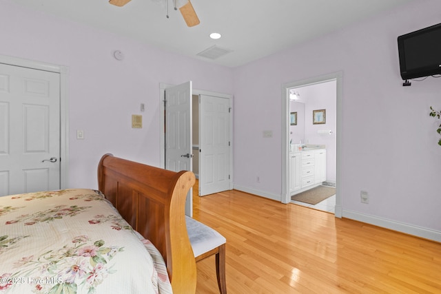 bedroom featuring ceiling fan, light hardwood / wood-style flooring, and ensuite bath