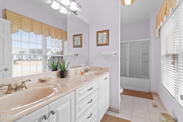 full bathroom featuring shower / bath combination with glass door, tile patterned flooring, vanity, and toilet