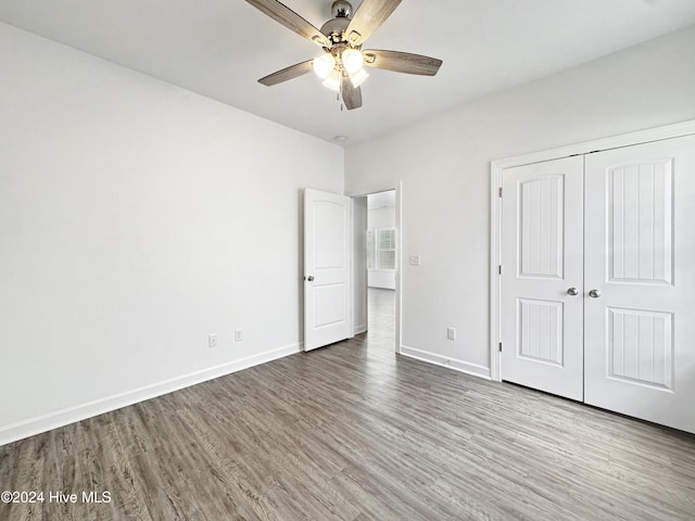 unfurnished bedroom with hardwood / wood-style flooring, ceiling fan, and a closet