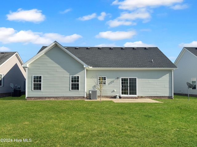 rear view of property featuring cooling unit, a patio area, and a yard