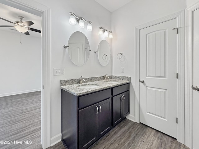 bathroom with ceiling fan, vanity, and wood-type flooring