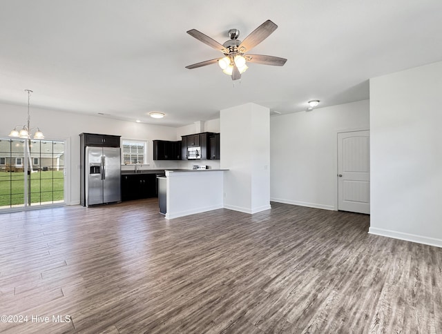 kitchen with ceiling fan with notable chandelier, dark hardwood / wood-style flooring, kitchen peninsula, and appliances with stainless steel finishes