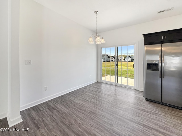 unfurnished dining area featuring dark hardwood / wood-style floors and a notable chandelier