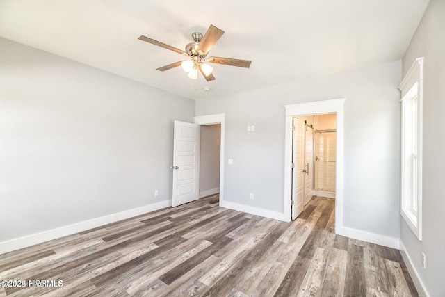 unfurnished bedroom featuring hardwood / wood-style flooring, ceiling fan, and ensuite bath