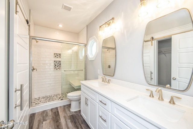 bathroom with vanity, wood-type flooring, an enclosed shower, and toilet