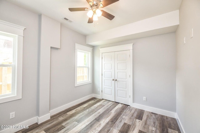 unfurnished bedroom featuring a closet, ceiling fan, and hardwood / wood-style flooring