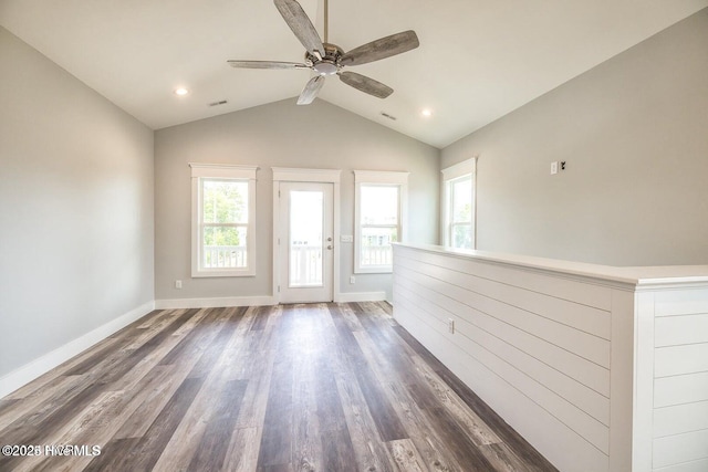 unfurnished room featuring ceiling fan, dark hardwood / wood-style flooring, a healthy amount of sunlight, and lofted ceiling