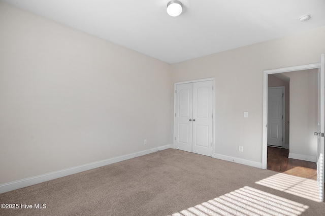 unfurnished bedroom with dark colored carpet and a closet