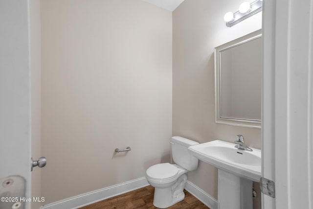 bathroom featuring sink, toilet, and hardwood / wood-style flooring