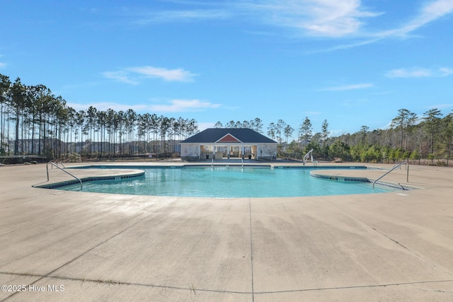 view of swimming pool featuring a patio and a hot tub