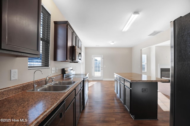 kitchen featuring sink, a center island, stainless steel appliances, dark hardwood / wood-style flooring, and a breakfast bar area