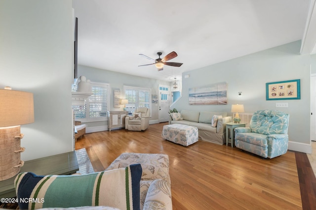 living room with ceiling fan and light hardwood / wood-style flooring