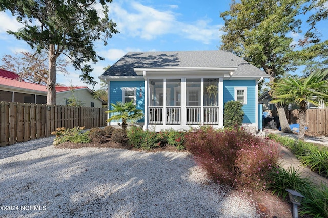 rear view of property featuring a sunroom